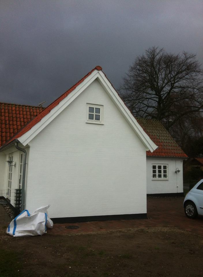 Fronten af en tilbygning på et hvidt hus